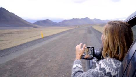 Fröhlich-kaukasischen-Frauen-Auto-Straße-ausgestreckten,-vulkanische-Berglandschaft-zu-betrachten.-Offroad-Reise-Konzept.--Blondes-Haar-Mädchen-Blick-auf-Landschaft.