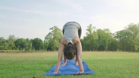 Junge-asiatische-Frau-Yoga-im-Freien-bleiben-Sie-ruhig-und-meditiert-beim-Üben-von-Yoga,-die-innere-Ruhe-zu-erkunden.-Yoga-und-Meditation-haben-gute-Vorteile-für-die-Gesundheit.-Yoga-Sport-und-gesunde-Lifestyle-Konzept.