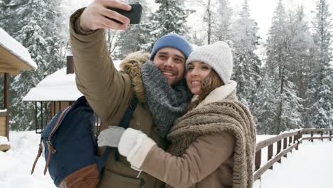 Happy-Couple-Photographing-in-Winter-Forest
