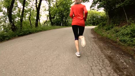 Niña-corriendo.-Chica-rubia-haciendo-deportes-al-aire-libre-en-el-bosque-de-verano.-Parte-trasera-vista-cámara-lenta-gran-angular.-Primer-plano-de-las-piernas-de-la-muchacha