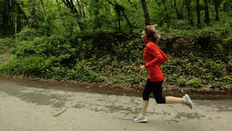 Running-girl.-Blonde-girl-doing-outdoor-sports-in-the-summer-forest.-Side-view-slow-motion-wide-angle