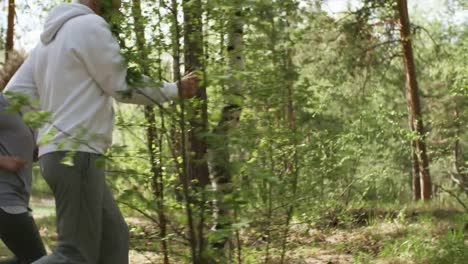 Elderly-Man-and-Woman-Jogging-in-Forest-in-Morning