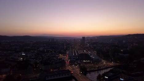 tráfico-de-estación-ferroviaria-famosa-puesta-de-sol-cielo-zurich-ciudad-centro-puente-panorama-4k-Suiza