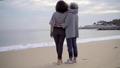 Dos-madurados-mujeres-turistas-hablando-y-abrazándose-en-la-costa.