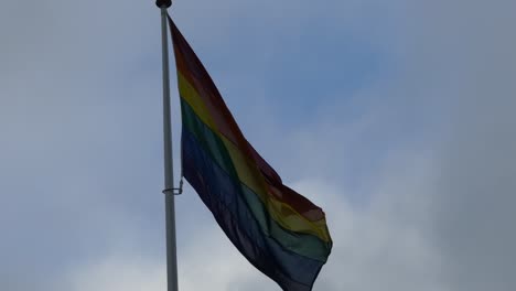 Regenbogenfahne-in-der-Innenstadt.-Regenbogenfahne-(LGBT-Bewegung)-flattert-im-Wind.-Nahaufnahme.