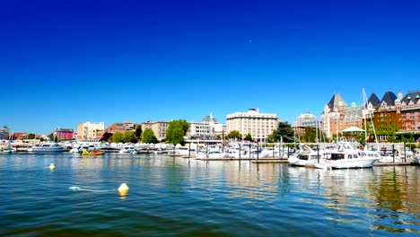 Victoria-City-Skyline-from-Inner-Harbor,-Boats-and-Planes,-Empress-Hotel