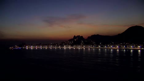 Low-angle-aerial-view-of-Rio-de-Janeiro-at-night,-Brazil