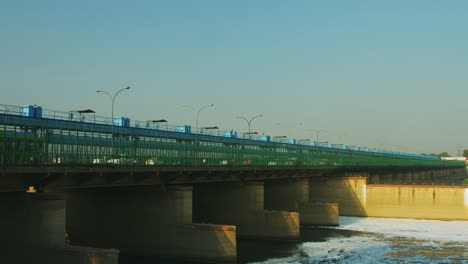 Time-Lapse-shot-of-vehicles-moving-on-bridge-over-a-river