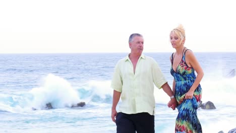 An-older-couple-holding-hands-and-walking-down-the-beach