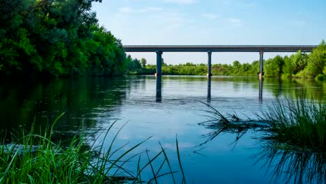 Timelapse-bridge-over-the-river-during-the-summer-spring-water-machines-movement-on-the-bridge