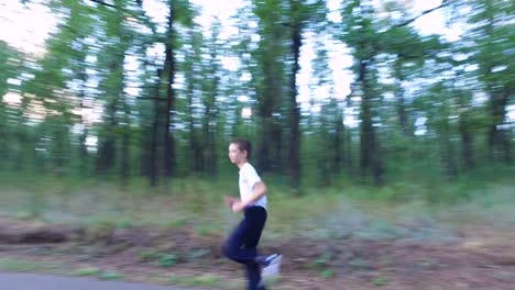 Hijo-adolescente-delgado-está-corriendo-en-senderos-y-senderos-en-el-bosque.-El-chico-está-entrenado-para-correr-bien.-Deportes-en-la-naturaleza.