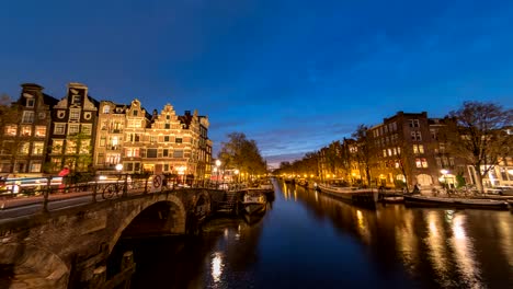 Amsterdam-city-skyline-night-timelapse-at-canal-waterfront,-Amsterdam,-Netherlands,-4K-Time-Lapse