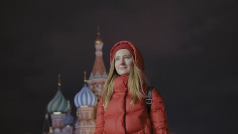 eine-nachdenkliche-schöne-junge-Frau-auf-dem-Roten-Platz-in-der-Nacht-ist-in-der-Ferne-suchen.