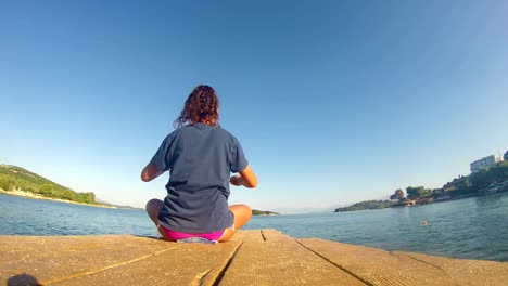 4-K-beach-yoga,-caucásico-chica-en-el-muelle-de-la-toma-ancha