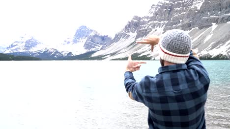 Young-man-framing-mountain-landscape-with-his-hands