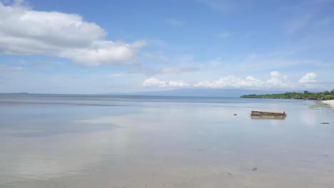 Drone-shot-aerial-view-of-young-man-playing-on-beach,-swing-rope-on-palm-tree.-Shot-in-the-Philippines,-4K-resolution-video.-People-travel-vacations-concept