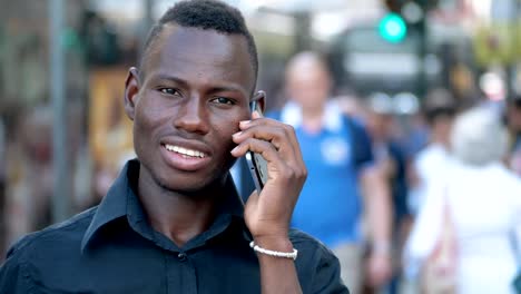 Porträt-des-jungen-schwarzen-afrikanischen-Mann-sprechen-per-Telefon-in-der-Stadt