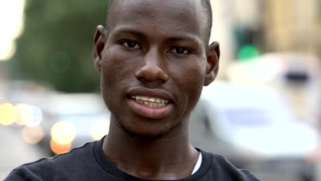 close-up-portarit-of-African--young-man-smiling-at-camera-in-the-street