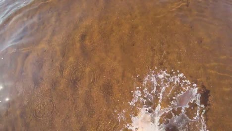 Top-view-barefoot-woman-walking-in-shallow-sea-water.-Selfie-shot.