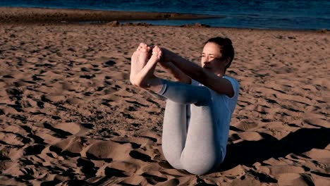 Woman-stretching-yoga-on-the-beach-by-the-river-in-the-city.-Beautiful-view.