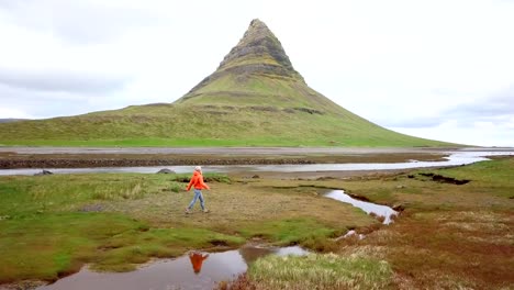 Drone-point-of-view-of-happy-girl-enjoying-nature-running-arms-outstretched-loving-life-and-freedom--People-travel-exploration-concept---4K-aerial-shot