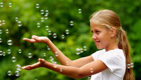 Little-girl-playing-with-soap-bubbles-outdoor.-Slow-motion.