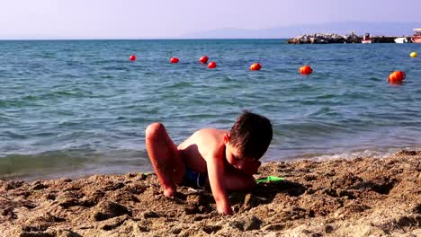 Little-boy-on-a-sea-beach-playing-in-the-sand