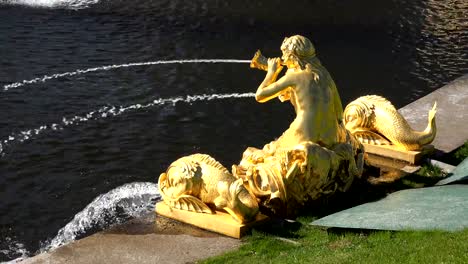 Wasserstrahlen-brechen-aus-einem-Brunnen-mit-vergoldeten-Statuen