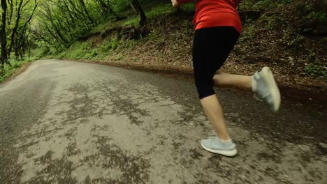 Niña-corriendo.-Chica-rubia-haciendo-deportes-al-aire-libre-en-el-bosque-de-verano.-Parte-trasera-vista-cámara-lenta-gran-angular.-Primer-plano-de-las-piernas-de-la-muchacha