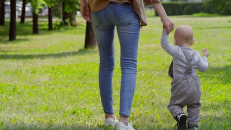 Madre-y-bebé-sostener-las-manos-y-caminando-en-el-Parque