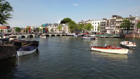 Traditionelle-Tourenboot-segelt-in-ikonische-Kanal-in-Amsterdam,-Holland-Europa