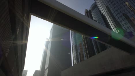 Sun-rays-shine-next-to-modern-skyscrapers-in-downtown-Los-Angeles-street-dolly-shot