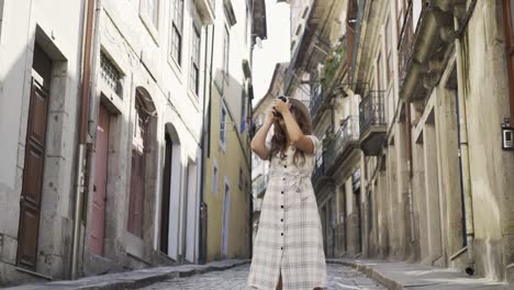 Woman-in-dress-and-hat-shooting-buildings-on-street