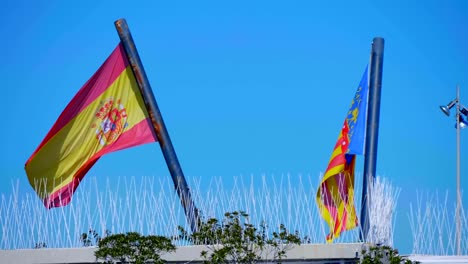 Große-Nationalflaggen-von-Spanien-und-Valencia-flattern-langsam-im-Wind