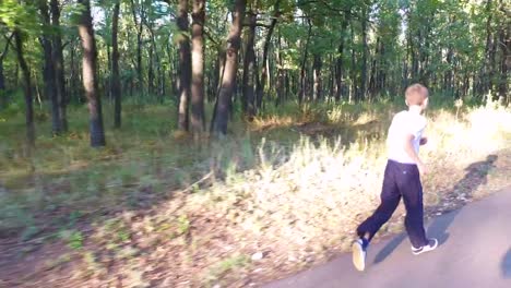 Hijo-adolescente-delgado-está-corriendo-en-senderos-y-senderos-en-el-bosque.-El-chico-está-entrenado-para-correr-bien.-Deportes-en-la-naturaleza.