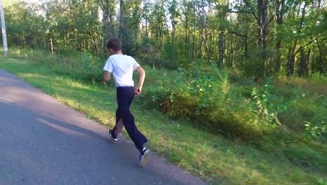 Hijo-adolescente-delgado-está-corriendo-en-senderos-y-senderos-en-el-bosque.-El-chico-está-entrenado-para-correr-bien.-Deportes-en-la-naturaleza.