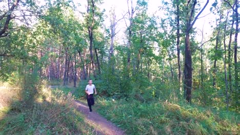 Hijo-adolescente-delgado-está-corriendo-en-senderos-y-senderos-en-el-bosque.-El-chico-está-entrenado-para-correr-bien.-Deportes-en-la-naturaleza.