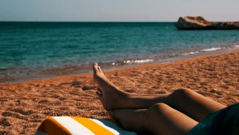 Piernas-de-mujer-tumbada-en-Beach-Sun-Lounger-cerca-del-Mar-Rojo,-Egipto