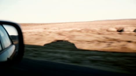 View-inside-the-car-on-countryside-road-on-desert.-View-of-the-vehicle-shadow-outside,-beautiful-sunset