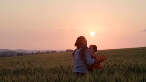 familia-asiática-en-un-campo-con-un-bebé-de-1-año-en-mano,-el-concepto-de-felicidad-de-la-familia,-hermosa-luz-del-sol,-puesta-de-sol,-cámara-lenta