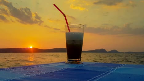 Eiskaffee-gegen-den-Sonnenuntergang-und-das-Meer.-Einen-schönen-ruhigen-Abend.