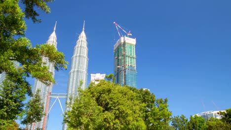 Las-Torres-Petronas-en-Kuala-Lumpur,-vista-desde-el-parque.-Timelapse-de-movimiento