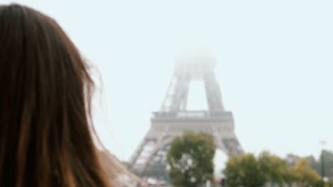 Close-up-view-of-young-woman-taking-photos-on-smartphone-of-Eiffel-tower.-Female-using-mobile-phone-in-Paris,-France