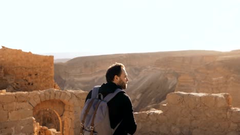 Male-tourist-photographs-amazing-mountain-scenery.-Young-man-with-backpack-takes-photos.-Freedom.-Masada-Israel-4K