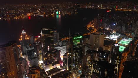 night-time-illuminated-hong-kong-cityscape-downtown-victoria-harbour-aerial-panorama-4k