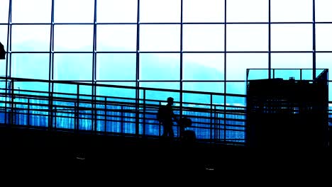 Sonnenuntergang-Silhouetten-der-Pendler-im-Flughafen.