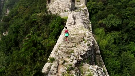 aerial-view-of-young-fitness-woman-trail-runner-running-on-top-of-great-wall