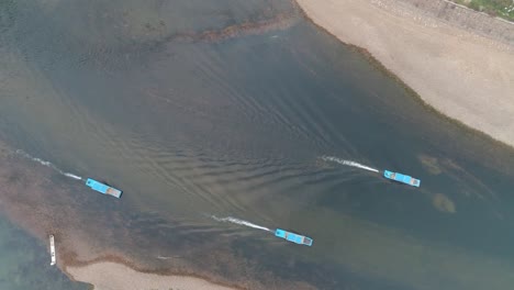 Sailboat-runs-along-the-river.-aerial-view-of-Li-River-floating-boats-and-Karst-mountains.-Located-near-The-Ancient-Town-of-Xingping,-Yangshuo-County,-Guilin-City,-Guangxi-Province,-China.