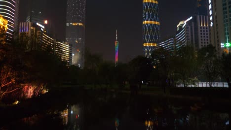 noche-iluminada-guangzhou-ciudad-megatalls-centro-edificios-estanque-reflexión-panorama-4k