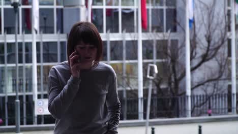 lady-is-walking-and-talking-on-the-phone-near-the-European-Parliament-in-Brussels.-Belgium.-slow-motion